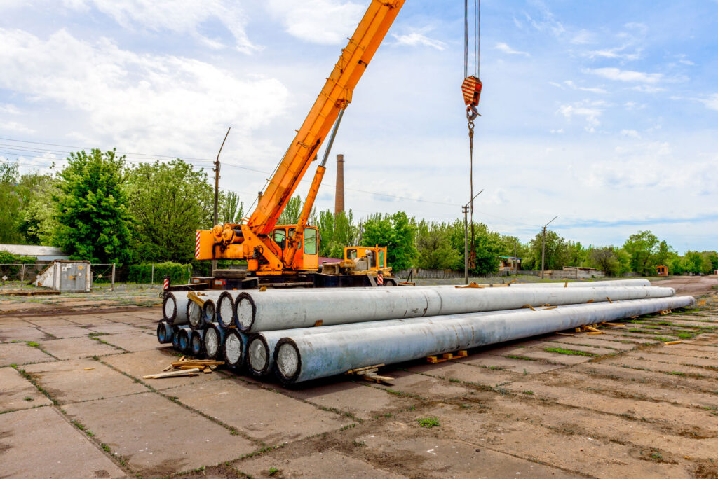 unloading-of-concrete-high-voltage-poles-at-the-co-2021-10-21-02-47-05-utc